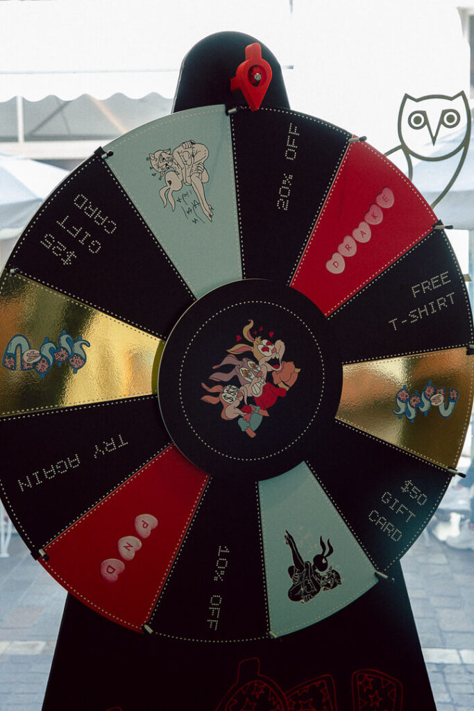 That Good Co A prize wheel with sections labeled 20% off, $50 gift card, free T-shirt, 10% off, and “Try Again,” featuring cartoon graphics and an owl logo in the background.